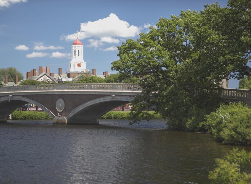 View of a bridge over the Charles river. Harvard campus can be seen in the background.