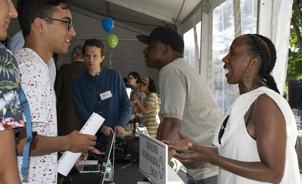 student and adviser talking at a table during the fair