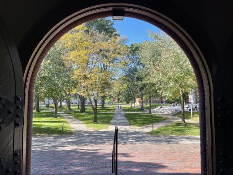 Views of Tercentenary Theater framed by the doorways of Sever Hall.