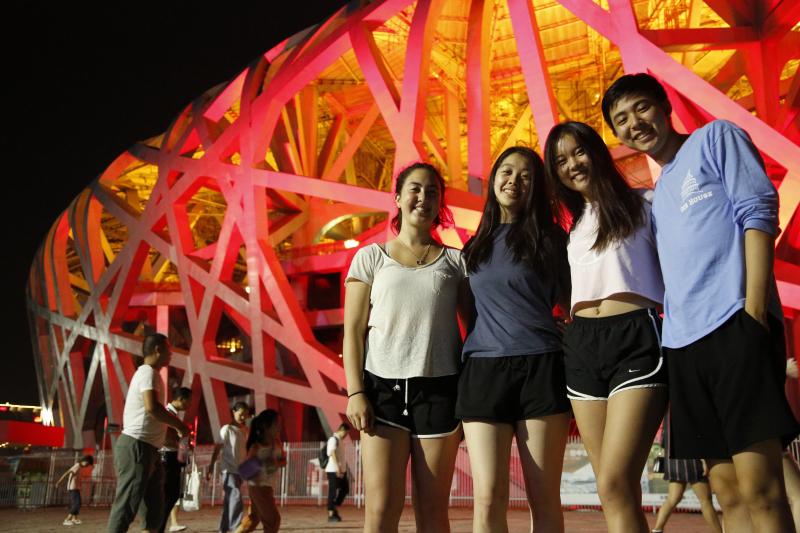 Four people standing in front of the Olympic Stadium in Beijing