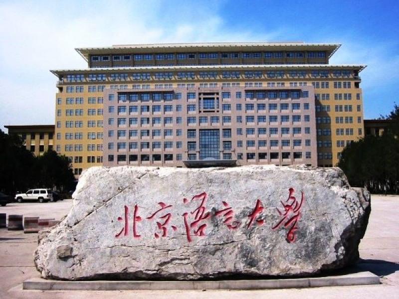 Stone with chinese characters in front of large classroom building
