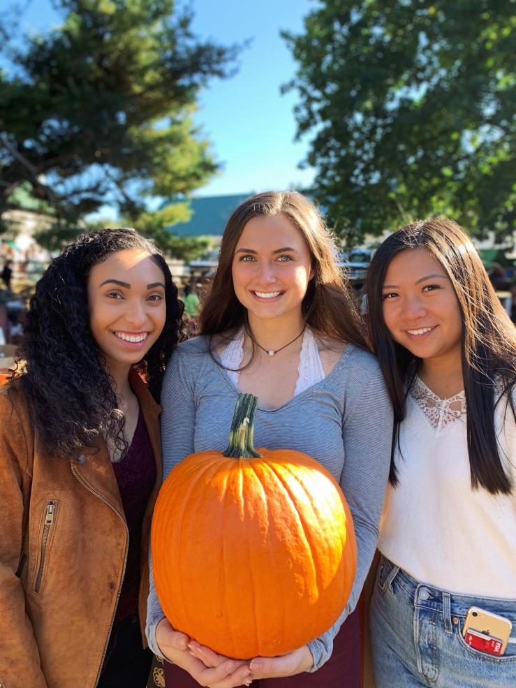 Three girls holding pumpkin